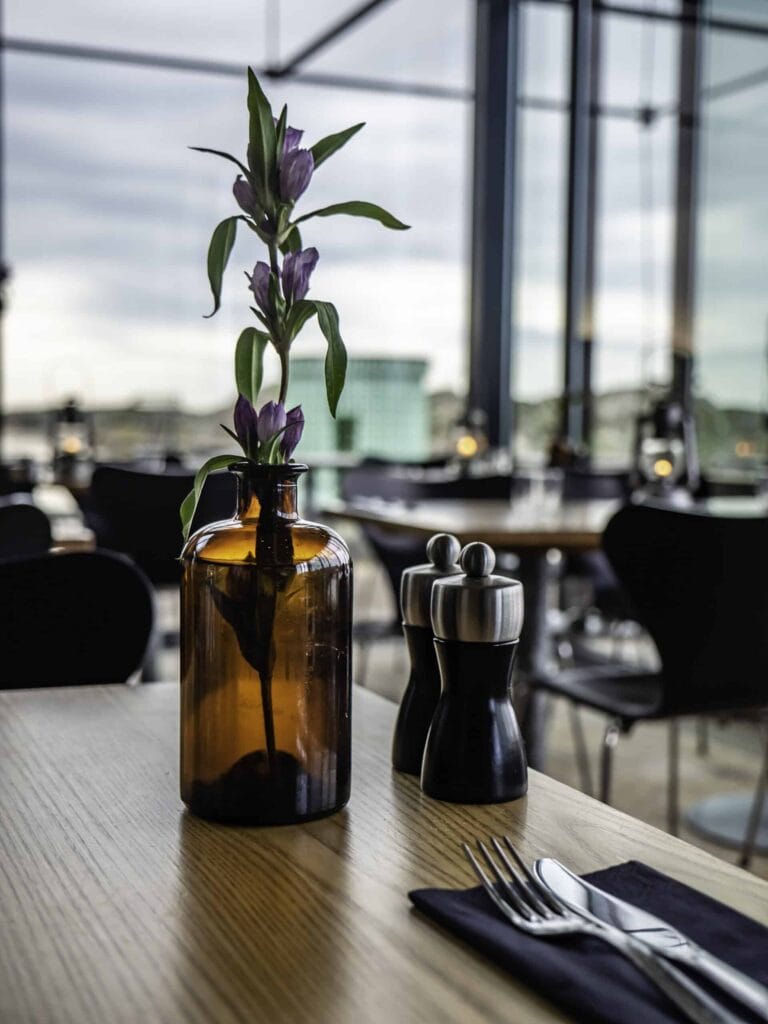 Blomma i glasflaska på restaurangbord