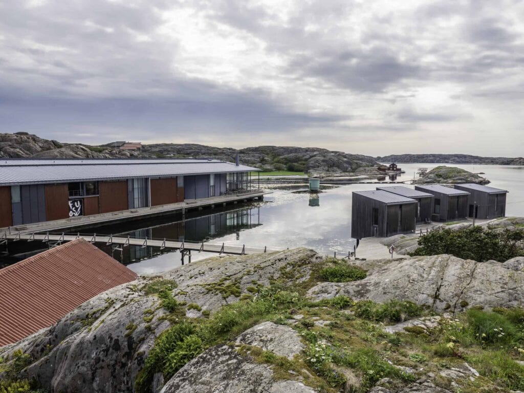 Skärgårdsbebyggelse vid vattnet under molnig himmel.