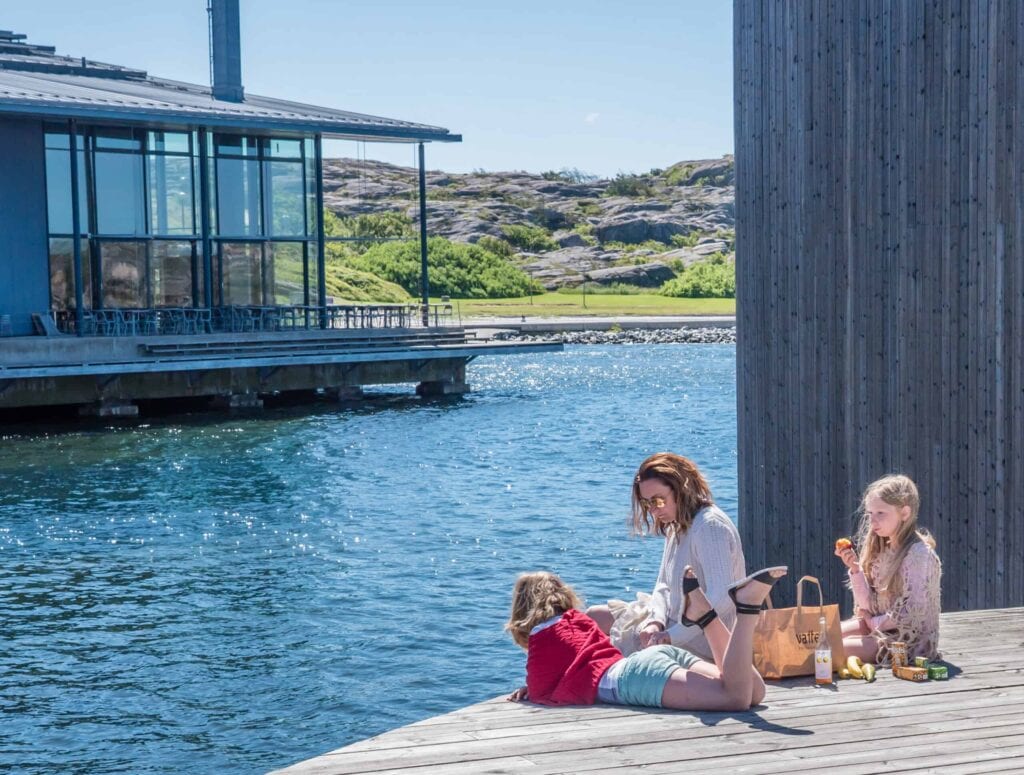 Familj njuter av soligt väder vid vattnet.